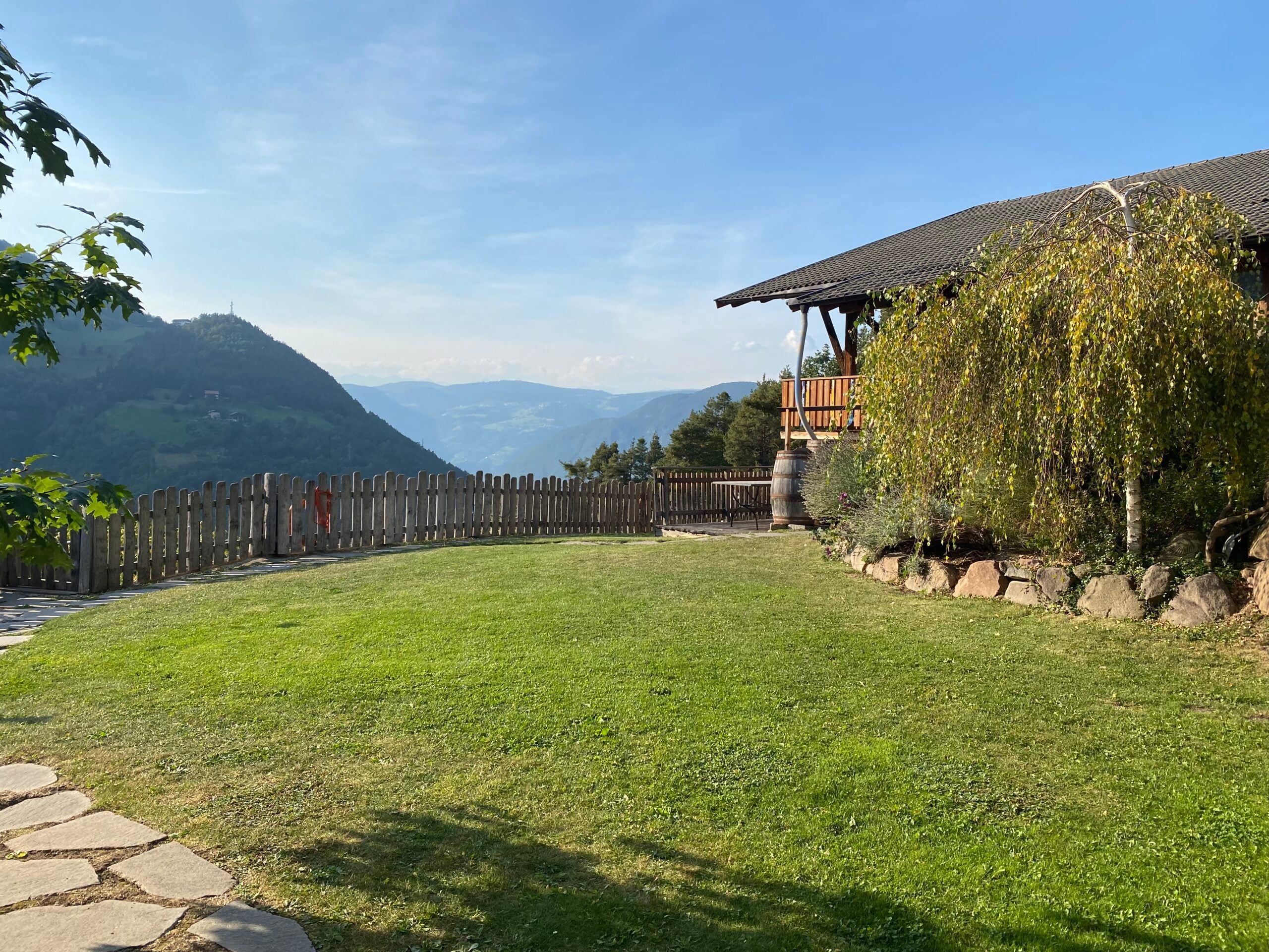 Große Rasenfläche vor dem Apartment Eiche mit Holzzaun und Blick in das Tal